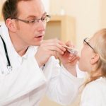 Доктор осматривает больного ребенка с кашлем