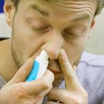 мужчина брызгает в нос
