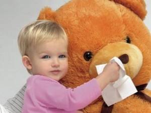 Ребенок вытирает нос медвежонку